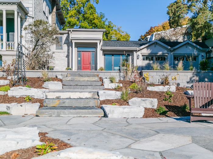 A full-property transformation featuring limestone steps, a flagstone courtyard, and a custom firepit with marina views.