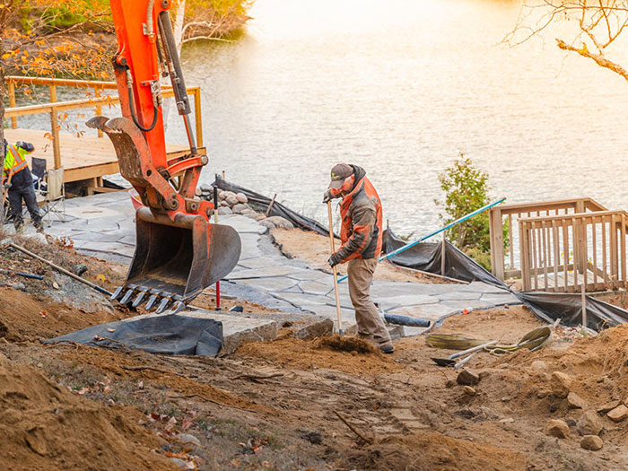 From fire pit to forest edge, this lakeside path blends local limestone, flagstone artistry, and rest stops into a serene journey up the slope.